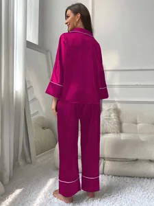 Back view of elegant magenta satin long-sleeve pajama set for women in cozy home setting
