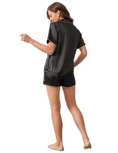 Back view of women's black satin pajama set featuring short sleeves and elegant white piping