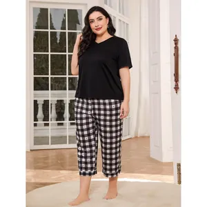 Plus size women's pajama set featuring black short sleeve top and heart checkered pants