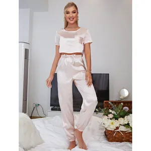 Elegant pink satin two-piece pajama set with crop short sleeve top and jogger pants