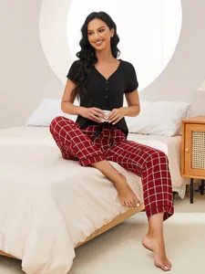 Close-up view of a woman wearing a black short-sleeved pajama top and red plaid pants.