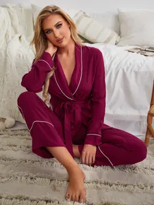 Primo piano dell'elegante set pigiama bordeaux da donna con vestaglia e pantaloni