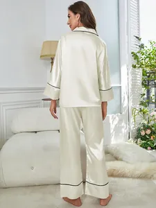 Back view of elegant ivory satin pajama set with black piping for women