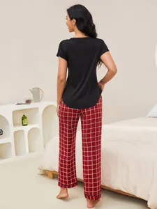 Back view of women's short sleeve black pajama top and red checkered loungewear pants