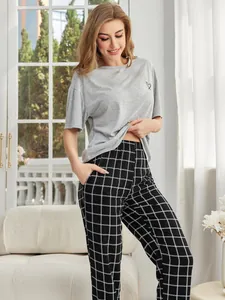 Lässiges Damen-Schlafanzug-Set mit grauem Kurzarm-Oberteil und einer karierten Hose.