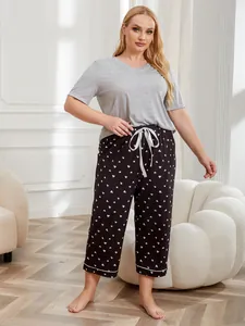 Full view of the plus size grey V-neck t-shirt and black heart print pajama pants set