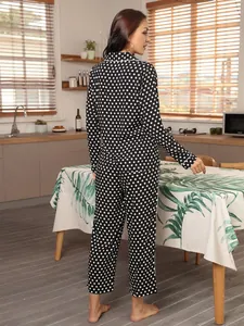 Achteraanzicht van een klassieke zwart-witte pyjamaset met stippen voor dames in keuken