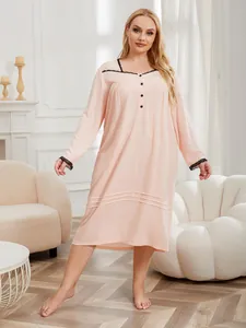 Plus size long-sleeved nightgown in peach with delicate black lace trim and button detail