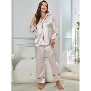 Elegant pink satin pajama set with long sleeves and black contrast piping detail.