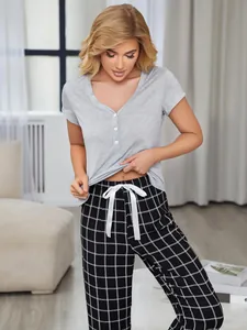 Detailed view of women's grey short-sleeve pajama top paired with black checkered lounge pants