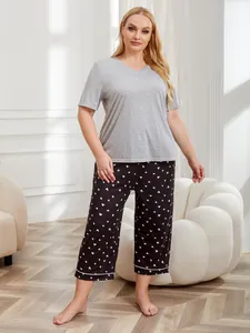 Full-length view of women's plus-size gray top and heart-patterned black pajama set.