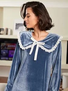 Close-up detail of a blue velvet nightgown with a white lace-trimmed collar and ribbon bow