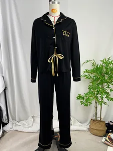 Klassieke zwarte dames pyjamaset met lange mouwen en goudkleurige biesafwerking