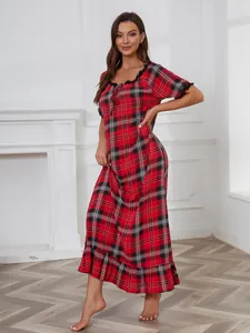 Gros plan sur une longue nuisette à carreaux rouges avec bordure en dentelle.