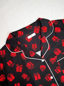 Detail view of women's black pajamas with red gift print and size S collar tag