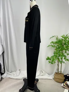 Detail van zwarte pyjamaset met lange mouwen en goudkleurige bies.