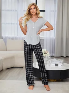 Elegant woman posing in gray short sleeve top and black checkered plaid pajama pants set