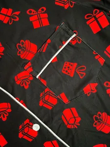 Close-up of women's Christmas pajamas with red gift box print and white piping detail