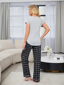 Back view of women's grey short sleeve top and checkered pajama pants in a living room