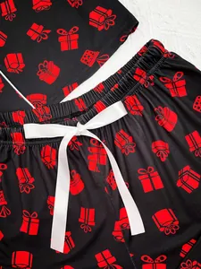 Close-up of red gift box print pajamas with elegant white satin ribbon bow detail