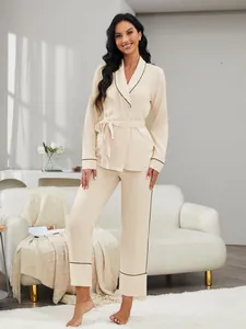 Elegante pigiama da donna color crema con profili neri a contrasto e cintura in vita
