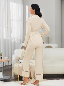 Vista posteriore di un elegante pigiama beige a due pezzi con bordini neri a contrasto