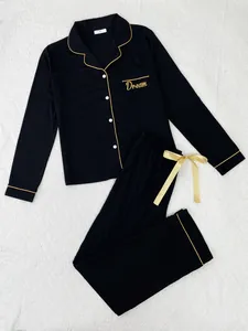 Elegant zwart tweedelig pyjamastel met gouden biezen en Dream-borduurdetails