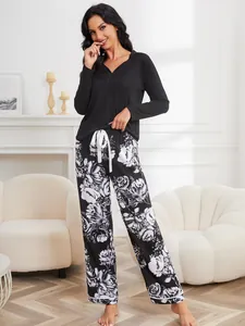 Elegant black long-sleeved pajama top paired with stylish white floral print pants