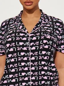 Detail of women's heart print pajama top with pink contrast piping and Love text