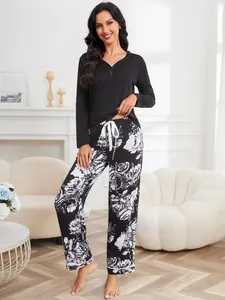 Elegant women's loungewear set with black long-sleeve top and floral printed pants