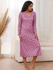 Vue détaillée d'une nuisette rose à manches longues avec un motif imprimé cœurs noirs.
