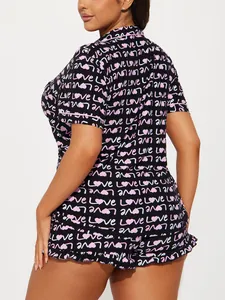 Detail view of women's short-sleeve pajama set featuring pink heart and love patterns.
