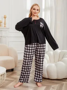 Cozy plus size two-piece pajama set featuring a black top and heart-patterned plaid pants.