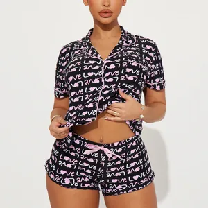 Two-piece women's pajama set featuring pink heart and love print on black fabric