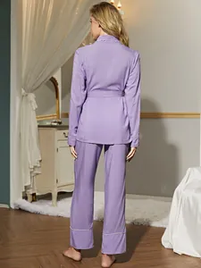 Dettaglio posteriore di un elegante pigiama viola a maniche lunghe con bordini bianchi.