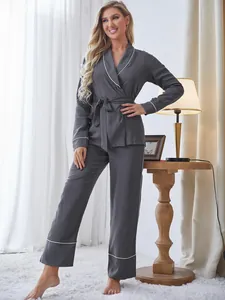 Vista a figura intera di una modella che indossa un pigiama grigio a due pezzi.