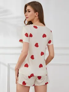 Back view of a cream pajama set with red heart prints, short sleeves and shorts.