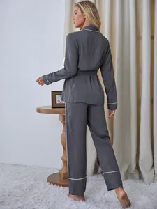 Vista posteriore di un elegante pigiama grigio a maniche lunghe da donna con bordino bianco