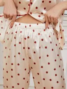 Vista dettagliata dei pantaloni del pigiama in raso con stampa coccinella