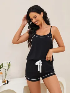 Detail of women's black two-piece camisole and shorts sleepwear with white trim