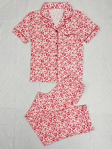 Flat lay of pink and red heart pattern pajamas set with short sleeves and pants