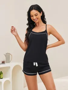 Detail shot of black two-piece pajama set with white piping and camisole top