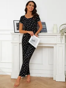 Detail view of two-piece pajama set for women with white heart print on black.