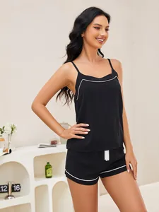 Close-up detail of a black camisole pajama set with elegant white piping trim for women