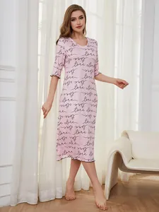 Model wearing a pink nightgown with heart and love script print in a bright room