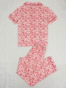 Short-sleeve pajama top and pants set featuring red heart patterns on white fabric