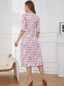 Detail view of pink women's nightgown featuring cursive love store letter prints and heart pattern.