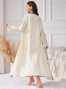 Vue arrière d'une élégante robe de chambre mi-longue crème avec détails en dentelle noire