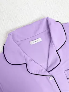 Close-up detail of purple ribbed pajama top with lapel collar and black piping