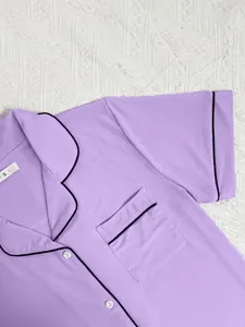 Detail of purple ribbed short-sleeve pajama top with black contrast piping